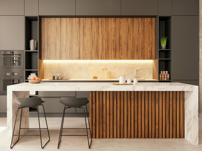 Moderne, minimalistisk kjøkken med integrerte detaljer og kjøkkenøy i tre og marmor.