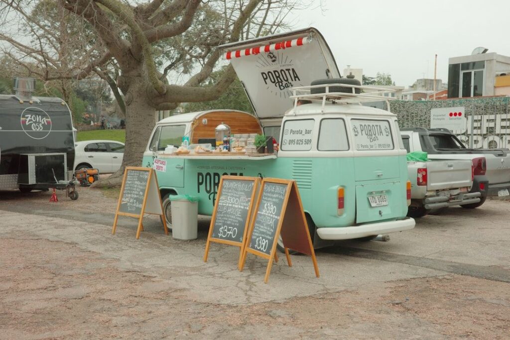 En lysegrønn Volkswagen kaffebil og food truck parkert utendørs.